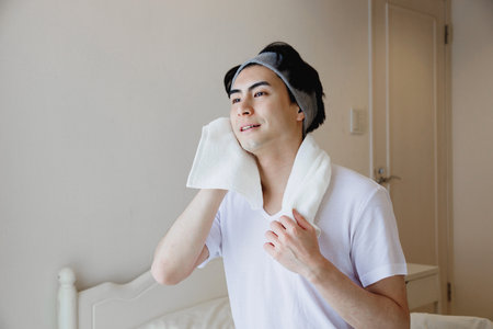 Japanese man using a towel to wipe his faceの写真素材