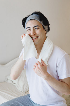 Japanese man using a towel to wipe his faceの写真素材