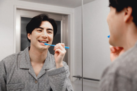 Japanese man in pajamas brushing his teethの写真素材