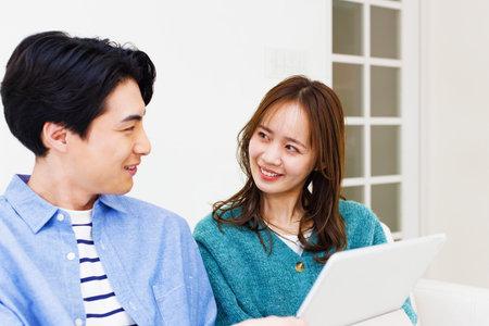 Japanese couple chatting in living roomの写真素材