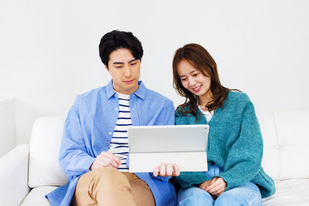 Japanese couple watching a digital tabletの写真素材