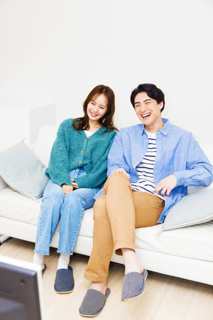 Japanese couple watching at televisionの写真素材