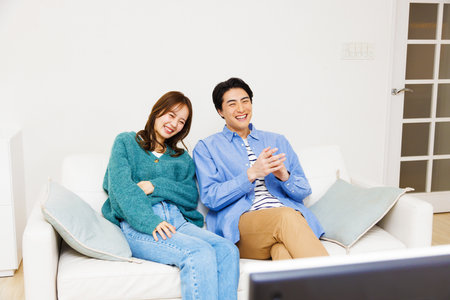 Japanese couple watching at televisionの写真素材