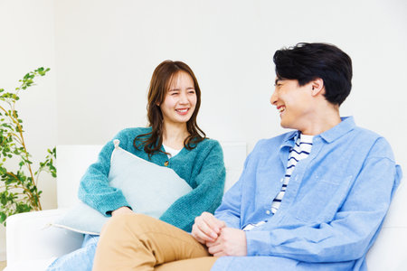 Japanese couple sitting in living roomの写真素材