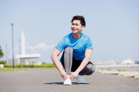 Man tying shoelace at parkの写真素材