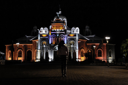 girl walking at night towards the churchの写真素材