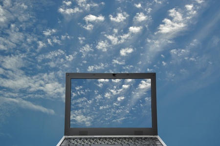 Black laptop on blue sky conceptの写真素材