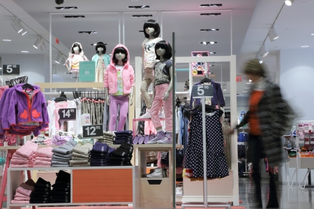 Shopper choosing dress in child clothes shop with motion blurのeditorial素材