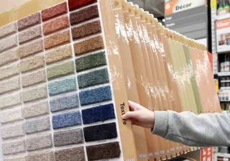 Woman choosing colorful carpet sample in storeのeditorial素材