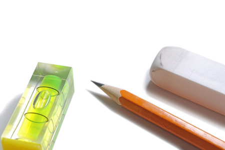 Pen, eraser and level on white background
