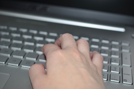 Female hands typing on a laptop