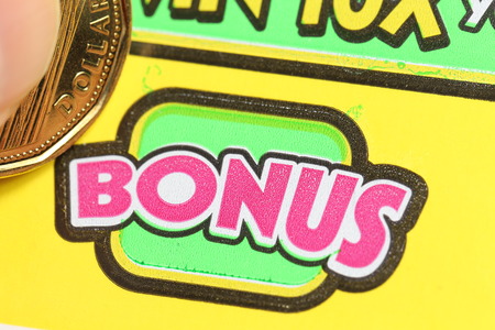 Coquitlam BC Canada - June 04, 2015 : Woman scratching lottery ticket on bonus section. The British Columbia Lottery Corporation has provided government sanctioned lottery games in British Columbia since 1985.のeditorial素材