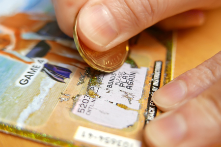 Coquitlam BC Canada - January 24, 2015 : Woman scratching lottery tickets. The British Columbia Lottery Corporation has provided government sanctioned lottery games in British Columbia since 1985.のeditorial素材