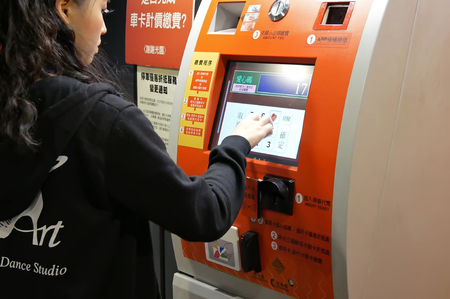 Taipei, Taiwan - October 28, 2017 : Motion of woman pressing plate number for paying parking fee at...