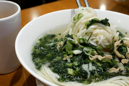 Motion of woman eating noodle soup inside Chinese restaurantの写真素材