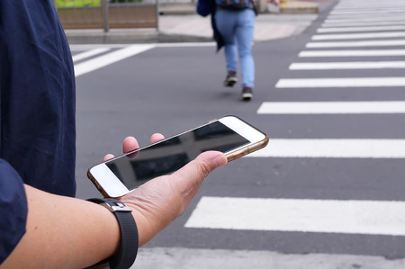 Motion of woman crossing street and holding phone in Taipei Taiwanの写真素材