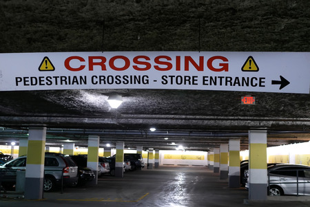 Coquitlam, BC, Canada - May 08, 2018 : Motion of pedestrian crossing and store entrance sign hanging on roof at parking lotのeditorial素材