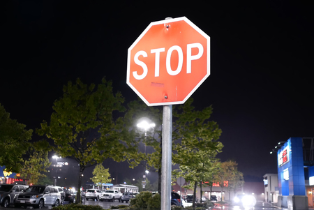 Coquitlam, BC, Canada - May 08, 2018 : Motion of stop sign in front of parking lot at raining nightのeditorial素材