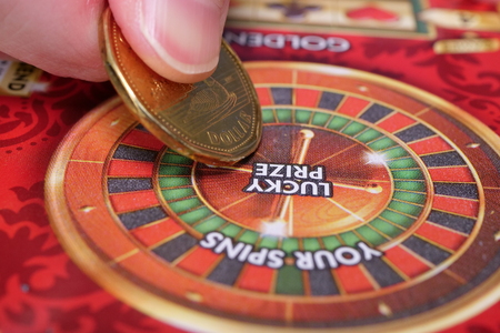 Coquitlam BC Canada - June 16, 2018 : Woman scratching lottery ticket. The British Columbia Lottery...