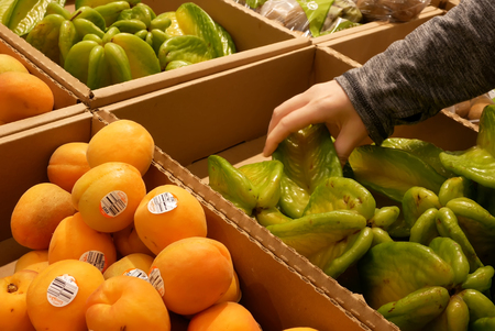 Coquitlam, BC, Canada - May 11, 2018 : Motion of woman's hand picking starfruit inside Superstoreのeditorial素材