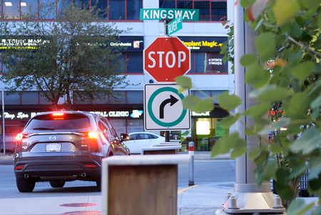 Burnaby, BC, Canada - May 30, 2018 : Motion of stop sign on sidewalk with blur traffic flow in Burnaby BC Canadaのeditorial素材