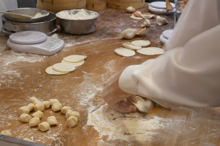 Motion of people are kneading the dough before it to be made dumplings inside restaurant kitchenの写真素材