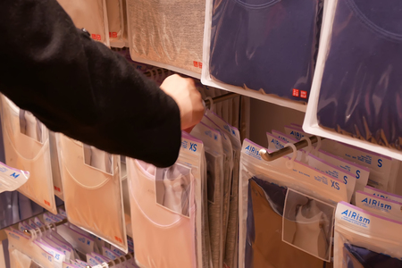 Coquitlam, BC, Canada - March 20, 2019 : Motion of woman buying clothes inside uniqlo storeのeditorial素材