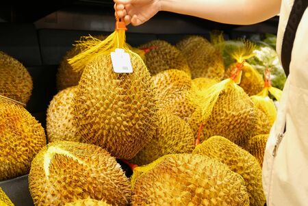Motion of woman's hand picking durian inside superstore