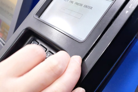 Close-up of a woman pressing a pin at self-checkout counter.