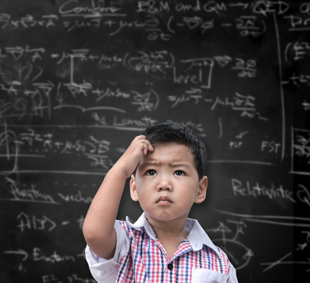 Thinking child with a blackboard in the backgroundの写真素材