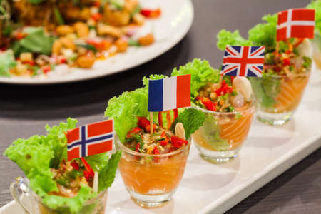 Spicy salmon with mixed vegetable and herb in glassの写真素材