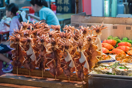KAOHSIUNG, TAIWAN - APR 20 : Chief prepares seafood to be sold in Kaohsiung night market on April 20, 2015. People enjoy food at night market in Taiwan. And is one of the unique culture in Taiwan.のeditorial素材