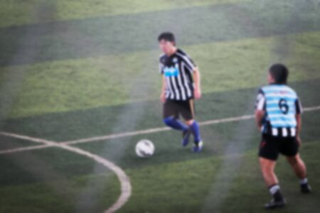 blurry soccer and football player training and playing football for backgroundの写真素材