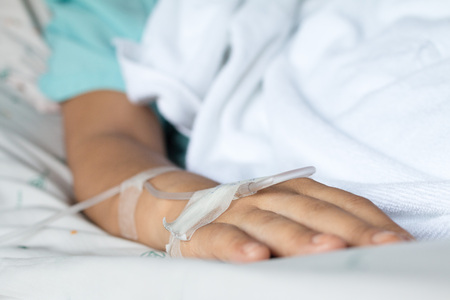 Focus on the hand of a patient near big window in hospital wardの写真素材