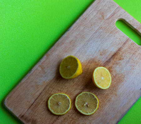 Slices of lemon on wooden cutting board.