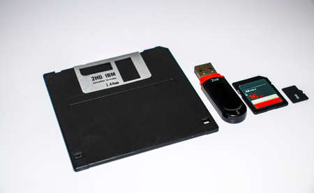 Old floppy disk, usb flash, memory card and micro memory card on white background. Indoors