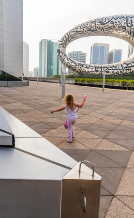 Dubai, UAE - 07.17.2022 Little girl playing at the platform in the front of a museum of futureのeditorial素材