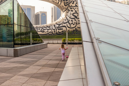 Dubai, UAE - 07.17.2022 Little girl playing at the platform in the front of a museum of futureのeditorial素材