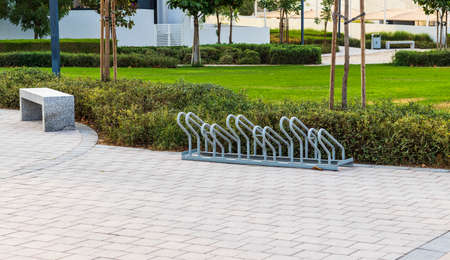 Shot of a bench and bicycle parking stand in the parkの写真素材
