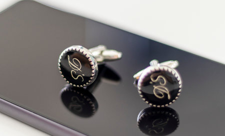 Close up shot of a silver cufflinks with letters D and S