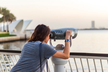 Woman looking trough binocular viewfinder.