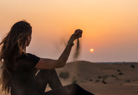 Silhouette of a woman in the desert during sunsetの写真素材