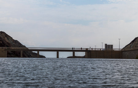 Shot of a people crossing the bridge above the water