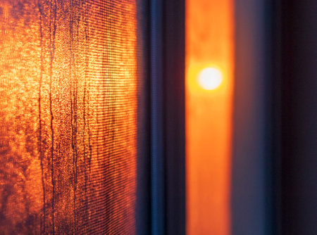 Shot of the sun setting and reflecting in the windowの写真素材