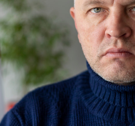 Portrait of the mid aged man with grey hair, wearing warm, dark blue sweater