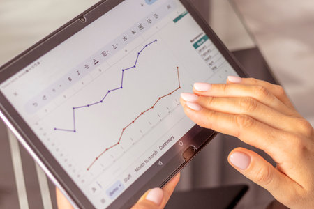 Close up shot of the woman with beautiful hands , using tablet, studying mortgage sales reportの写真素材