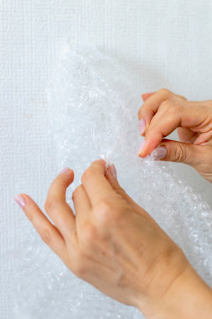 Shot of the woman bursts bubble wrap.