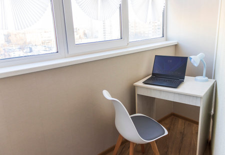 Tiny working space in the apartment. Laptop on the deskの写真素材