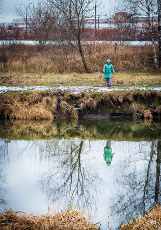 Shot of the woman fishing on the winter riverの写真素材