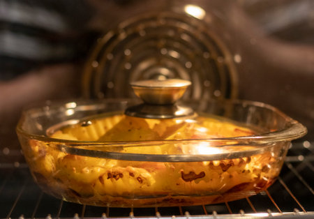 Vegetables baking in the transparent dish in the oven.の写真素材